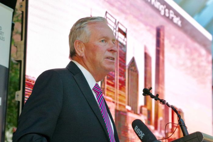 Mr Barnett standing in front of a picture of the proposed World Trade Center.