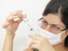 Female doctor wearing face mask prepares syringe for injection