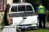 A police officer inspects a car that crashed into a house in the Perth suburb of Gosnells.