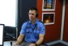 Senior Sergeant Dean Snashall sits in an ABC studio with headphones on in his police uniform