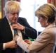 British Foreign Secretary Boris Johnson has his tie straightened by his Australian counterpart Foreign Minister Julie ...