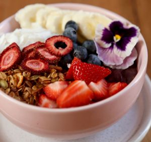 Acai bowl with banana, berries, coconut and granola.