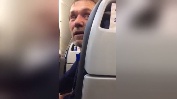 An image from a video a passenger on the United flight filmed of a man and woman being escorted off of the plane after ...