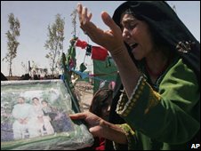 Afghan civilian holds a picture of family members allegedly killed by the US