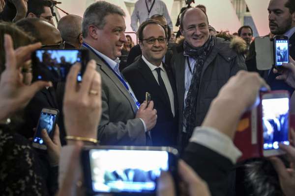 French President Francois Hollande is photographed by Disney cast members at the Disneyland Paris theme parks in Marne-la-Vallee, north of Paris, Saturday Feb. 25, 2017. Hollande visited Disneyland Paris to mark its 25th anniversary, as Europe's most popular tourist attraction struggles with long-running financial challenges. (Christophe Petit Tesson/Pool photo via AP)