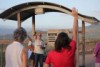 Rev Stuart Hall leads a group in prayer in front of the Ross Dam water level sign