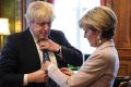 British Foreign Secretary Boris Johnson has his tie straightened by his Australian counterpart, Foreign Minister Julie ...