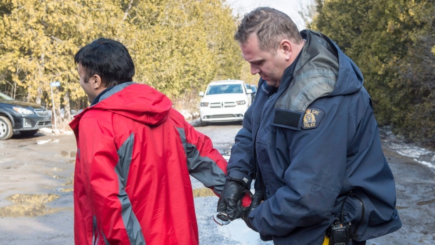 An asylum claimant claiming to be from Turkey is arrested after crossing the border into Canada from the United States on Thursday, February 23, 2017 near Hemmingford, Que. A growing number of people have been walking across the border into Canada to claim refugee status.