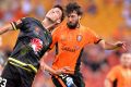 Head-to-head: Thomas Broich of the Roar and Matthew Ridenton of the Phoenix challenge for the ball.