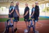 Students Nikki and Paityn stand on chairs next to Port Adelaide players Jackson Trengrove, Dan Hewson and Todd Marshall.