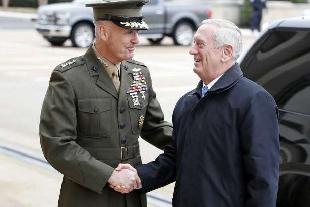 FILE - In this Jan. 21, 2107 file photo, Joint Chiefs Chairman Gen. Joseph Dunford greets Defense Secretary Jimn Mattis at the Pentagon. A new military strategy to meet President Donald Trump’s demand “to obliterate” the Islamic State group is likely to deepen U.S. military involvement in Syria, possibly with more ground troops, even as the current U.S. approach in Iraq appears to be working and will require fewer changes. Dunford said Feb. 23 that the strategy will take aim not just at the Islamic State but at al-Qaida and other extremist organizations in the Middle East and beyond whose goal is to attack the United States. He emphasized that it would not rest mainly on military might.