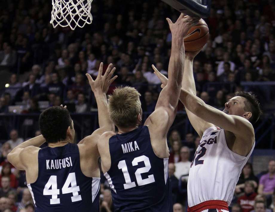 Gonzaga forward Zach Collins, right, shoots against BYU forward Eric Mika (12) and center Corbin Kaufusi (44) during the first half of an NCAA college basketball game in Spokane, Wash., Saturday, Feb. 25, 2017. Photo: Young Kwak, AP / FR159675 AP