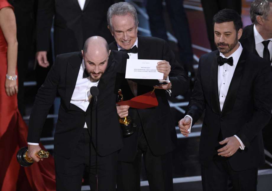 Jordan Horowitz, producer of "La La Land," shows the envelope revealing "Moonlight" as the true winner of best picture at the Oscars on Sunday, Feb. 26, 2017, at the Dolby Theatre in Los Angeles. Presenter Warren Beatty and host Jimmy Kimmel look on from right. (Photo by Chris Pizzello/Invision/AP) Photo: Chris Pizzello, Chris Pizzello/Invision/AP / 2017 Invision