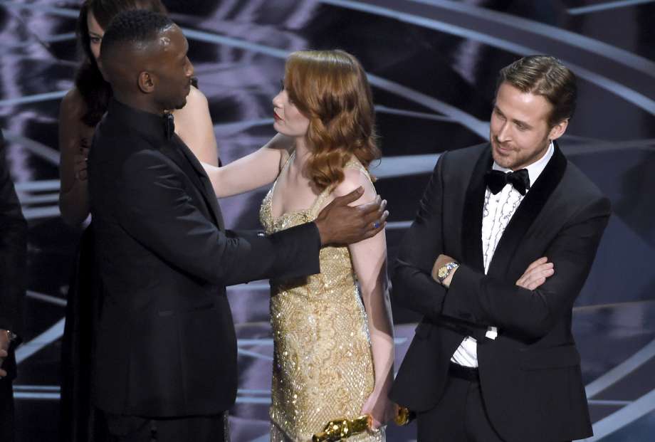 Ryan Gosling, right, stands with his arms folded as Emma Stone, center, congratulates Mahershala Ali, for winning the award for best picture for "Moonlight" at the Oscars on Sunday, Feb. 26, 2017, at the Dolby Theatre in Los Angeles. It was originally announced mistakenly that "La La Land" was the winner. (Photo by Chris Pizzello/Invision/AP) Photo: Chris Pizzello, Associated Press