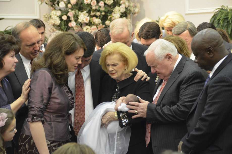 In this 2012 photo provided by a former member of the church, Word of Faith Fellowship leader Jane Whaley, center, holds a baby, accompanied by her husband, Sam, center right, and others during a ceremony in the church's compound in Spindale, N.C. From all over the world, they flocked to this tiny town in the foothills of the Blue Ridge Mountains, lured by promises of inner peace and eternal life. What many found instead: years of terror _ waged in the name of the Lord. Photo: AP / via AP