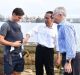 President Joko Widodo and Prime Minister Malcolm Turnbull talk to a father carrying his eight-week-old baby.