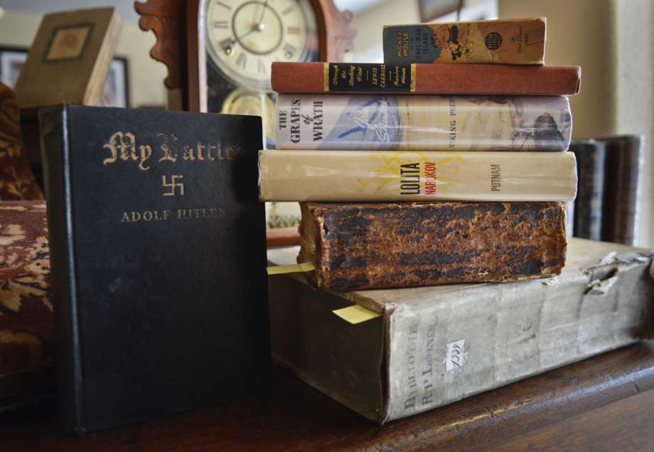 In this Jan. 19, 2017 photo, a collection of books is displayed in the home of Mike Vincent, a retired teacher, who has been collecting books since he got "Tom Sawyer" in fifth grade,  in Albuquerque, N.M. This stack includes a theological book from 1634, a Civil War era Bible, with inscribed personal notes about a family's experience during the war, "Lolita" by Vladimir Nabokov, John Steinbeck's "Grapes of Wrath", "Through the Looking-Glass" by Louis Carroll, a Mickey Mouse book from 1940 and "My Battle" by Adolphe Hitler.  (Marla Brose /The Albuquerque Journal via AP) Photo: Marla Brose, AP / Albuquerque Journal