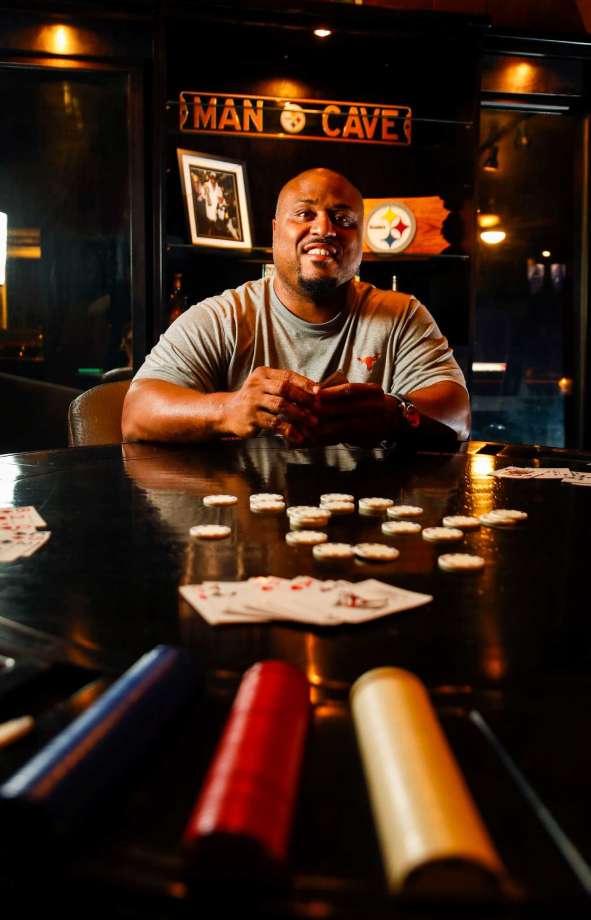 Two-time Super Bowl champ Casey Hampton, who played for the Pittsburgh Steelers, 
enjoys card games and dominoes in his man cave. Though spare on sports  memorabilia, his décor includes an ESPN cover featuring his team, right. Photo: Karen Warren, Staff Photographer / 2016 Houston Chronicle