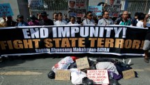 Activists protest using corpse effigies outside the police headquarters.