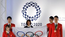 Japanese Olympians hold the Olympic flag during the Olympic and Paralympic flag-raising ceremony.