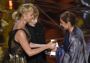 Charlize Theron, left, and Shirley MacLaine, present the award for best foreign language film to Anousheh Ansari on behalf of Asghar Farhadi for "The Salesman" at the Oscars on Sunday, Feb. 26, 2017