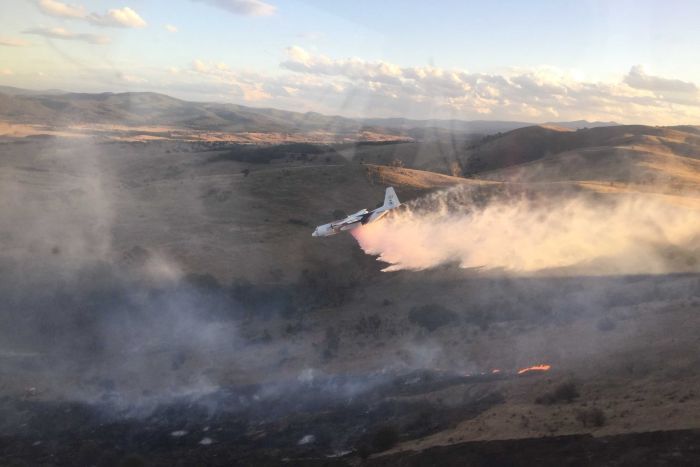 An aircraft drops retardant on the Carwoola fire.