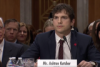 Ashton Kutcher sits behind a placard of his name, addressing the US Senate Committee ending modern slavery