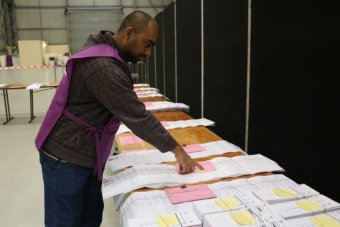 Australian Electoral Commission representative examines Senate ballot papers