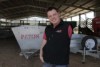 Man with one arm stands in cattle yard