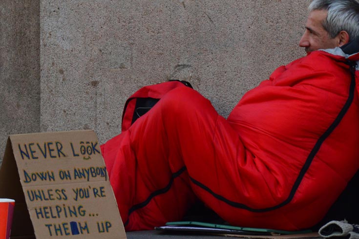 Homeless man with a sign: Never look down on anybody unless you&#039;re helping them up