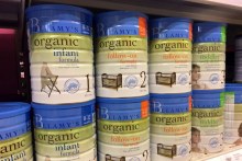 Tins of infant formula sitting on the shelf