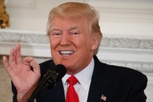 Donald Trump gestures with his hand while making a speech at the White House.