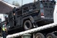 Victoria Police's Lenco BearCat is towed from the scene of the St Albans siege. 