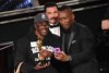 Mahershala Ali takes a selfie with a fan holding his Oscar