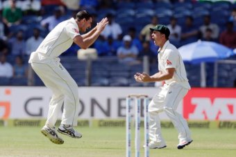 Mitchell Starc (L) and Steve O'Keefe celebrate the dismissal of India captain Virat Kohli in Pune.