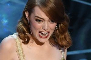 Emma Stone accepts the Oscar for best actress.