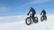 Deux cyclistes vêtus de vêtements d'hiver et de lunettes de ski roulent sur les glaces du lac Saint-Jean.