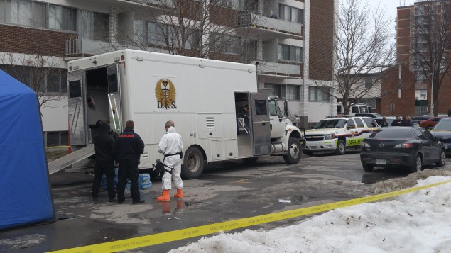 Une voiture des ambulanciers paramédicaux, un camion blanc et une banderole jaune de la police inique que l'opération policière est en cours.