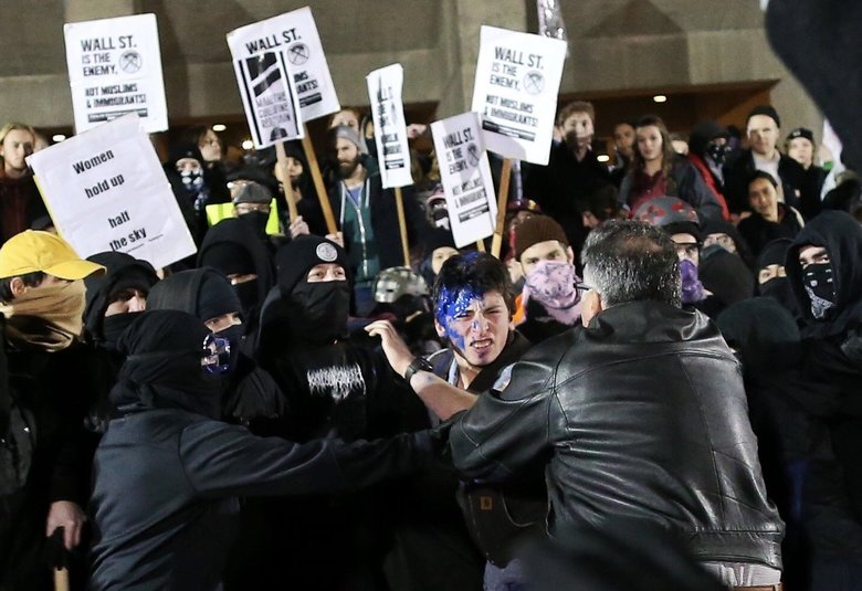 Alex St. Hilaire, a student at Mariner High School, is helped by his father, right, after being beaten outside of Kane Hall. (Johnny Andrews/The Seattle Times)