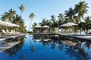 Sun loungers and parasols by the pool at Vomo Island Resort.