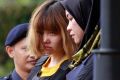 Vietnamese murder suspect Doan Thi Huong, second from right, is escorted by police officers out of Sepang court in ...