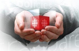 Hands holding a glass cube containing  a red cbc cube