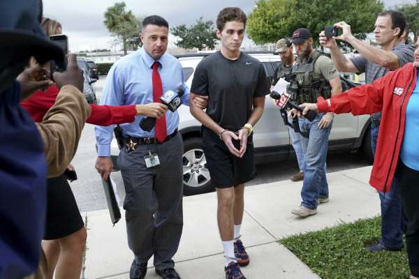 FILE - In this Monday, Oct. 3, 2016, file photo, Austin Harrouff is transported by detectives to the Martin County Jail from St. Mary's Hospital in Florida. Harrouff, the Florida college student accused of randomly killing a couple and chewing on the dead man's face, told TV personality Phil McGraw he had been running from a demon-like figure named Daniel before the attack. In a video released Tuesday, Feb. 28, 2017, by prosecutors, Harrouff told McGraw he only had vague memories of killing John Stevens and Michelle Mishcon last Aug. 15. (Richard Graulich/Palm Beach Post via AP)