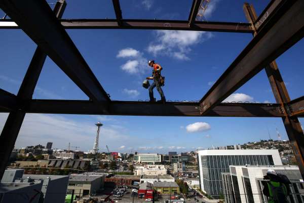 Iron worker Jake Lucas balances as he negotiates a beam on the 11th floor of Vulcan's Block 45 Project in South Lake Union. The building is being assembled faster than most as two tower cranes are being used on the project. When finished the building will be 12 stories tall and almost 500,000 square feet. Photographed on Thursday, October 2, 2014.