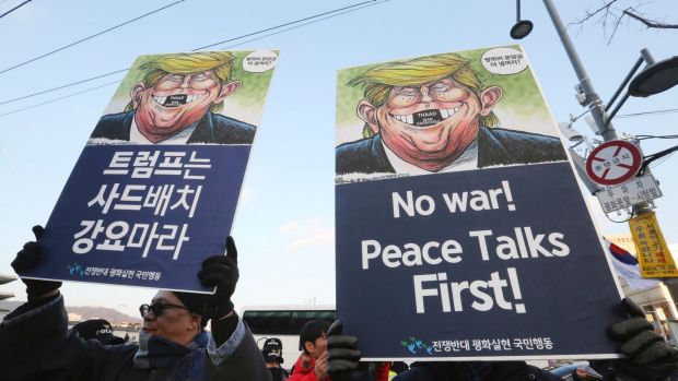 South Korean protesters hold up cartoons depicting US President Donald Trump during a rally against US Defence Secretary ...