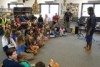 Clinton standing at front of the classroom talking to children