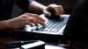 A woman's hands type on a laptop keyboard.