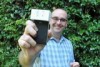 Man holding a smartphone with a 3D printed device attached in front of him