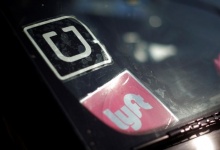 A driver displays Uber and Lyft ride sharing signs in his car windscreen in Santa Monica, California, U.S., May 23, 2016. REUTERS/Lucy Nicholson/Files