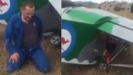 A man sits in shock after crash landing in a paddock, west of Canberra